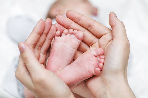 赤ちゃんの足母親の手に新生児の足。赤ちゃんの足は母親の手にカップ - 写真・画像