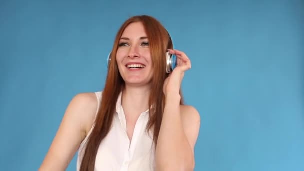 Jovial young woman dancing while listening to music in headphones. - Video, Çekim