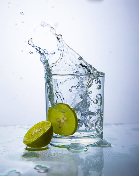 lime slices and water splash in glass - Фото, зображення