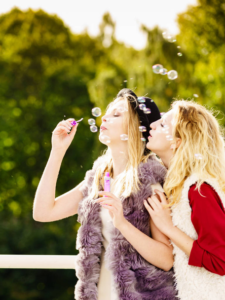 Women blowing soap bubbles, having fun - Valokuva, kuva