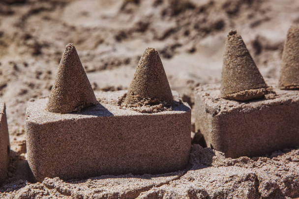 Castelo de areia em pé na praia. Conceito de férias de viagem. - Foto, Imagem