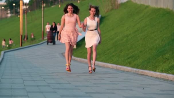twee vriendinnen springen op een stoep hand in hand - Video