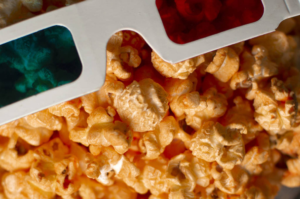 3d paper glasses and cheesy popcorn close up - Foto, imagen