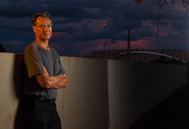 Portrait of a Middle Aged Mature Man Leaning Against a Wall at Sunset  - Photo, Image