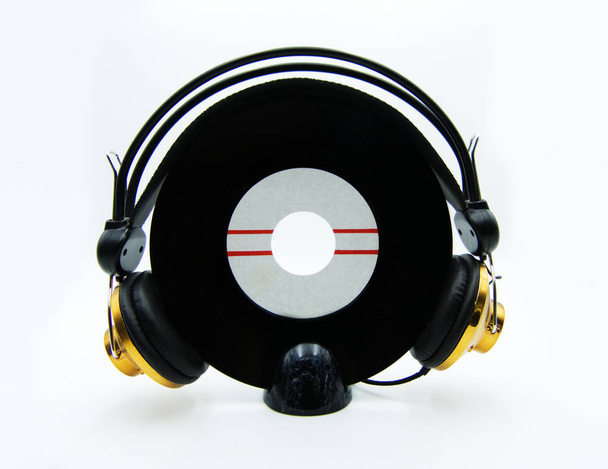 Vinyl-Single-Platte mit goldenen Kopfhörern auf weißem Hintergrund - Foto, Bild