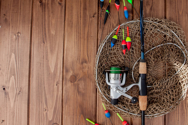 Fishing tackle - fishing rod fishing float and lures on beautiful blue wooden background, copy space - Foto, imagen