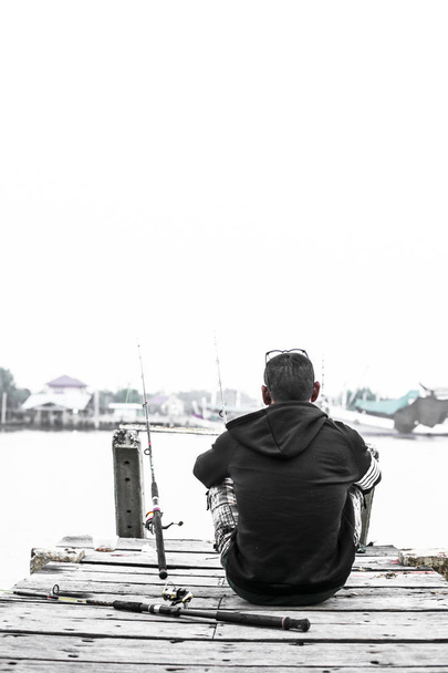 Wędkarz łowienie ryb z kamienia brzegu - Zdjęcie, obraz