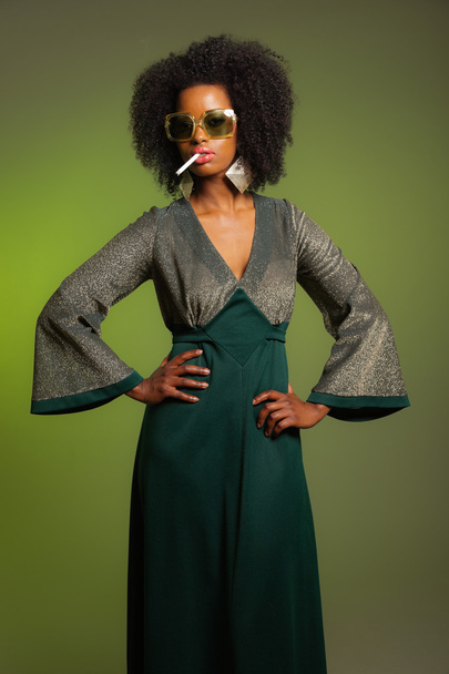 Dohányzás retro hetvenes évek divat afro nő zöld ruhában és sungla - Fotó, kép