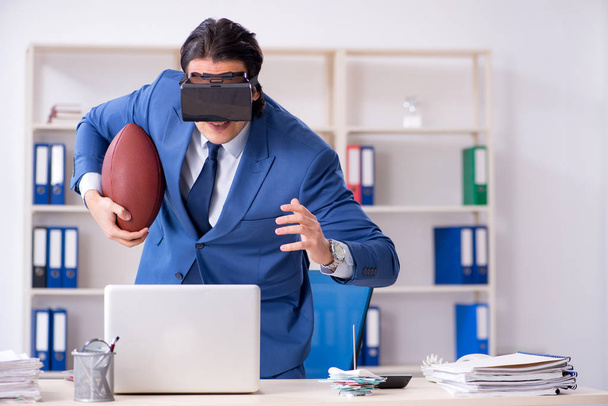 junger gutaussehender Geschäftsmann spielt Rugby mit virtueller Brille - Foto, Bild