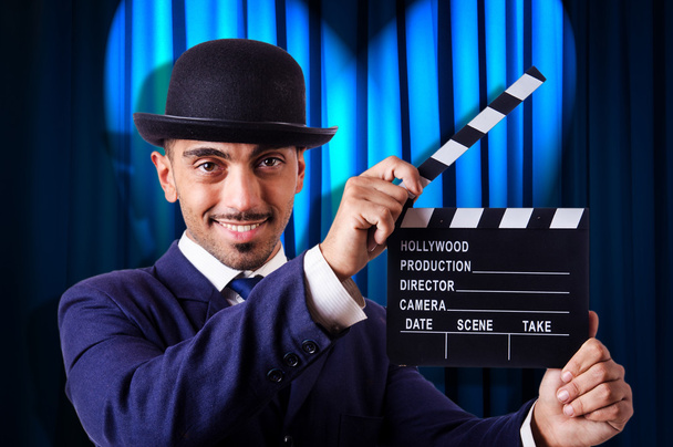 Mann mit Filmklöppel auf Vorhang-Hintergrund - Foto, Bild
