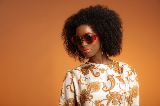 την δεκαετία του 70 ρετρό μόδα αφρικανή με paisley φόρεμα και sunglasse - Φωτογραφία, εικόνα