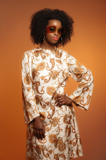Retro 70s mode Afrikaanse vrouw met paisley jurk en sunglasse - Foto, afbeelding