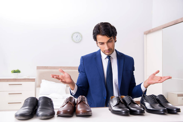 Young handsome businessman choosing shoes at home  - Photo, Image