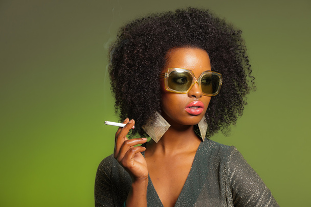 Fumar retro 70s moda afro mujer con vestido verde y sungla
 - Foto, Imagen