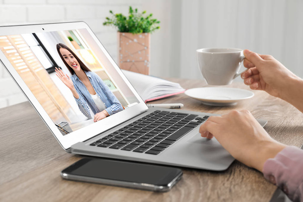 Woman using laptop for conversation via video chat at table, closeup - Foto, Imagen
