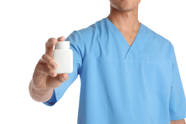 Male doctor holding pill bottle on white background, closeup with space for text. Medical object - Photo, Image