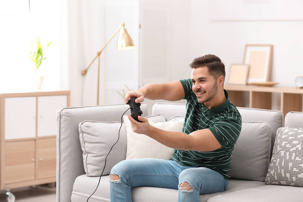 Emotional young man playing video games at home - Foto, imagen