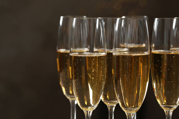 Glasses of champagne on dark background, closeup. Space for text - Foto, imagen