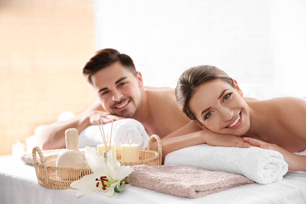 Young couple with spa essentials in wellness center - Фото, зображення