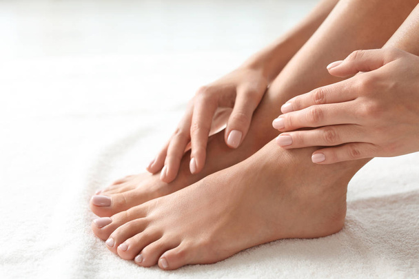 Woman with beautiful feet on white towel, closeup. Spa treatment - Foto, afbeelding