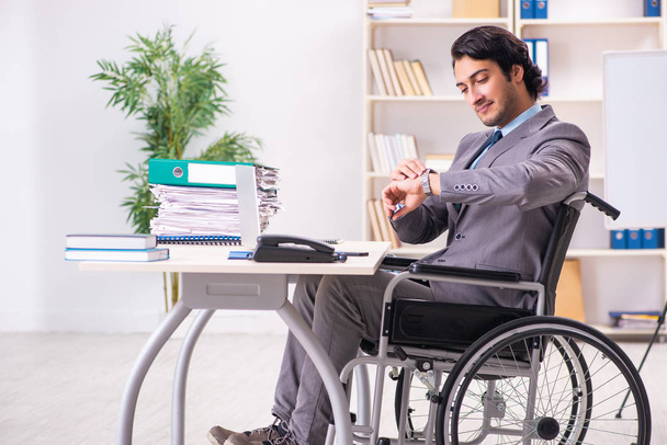 Young handsome employee in wheelchair at the office  - Foto, Imagen