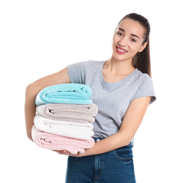 Happy young woman holding clean towels on white background. Laundry day - Valokuva, kuva