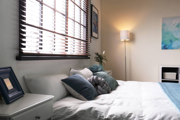 Quarto moderno interior com cama de casal confortável e persianas
 - Foto, Imagem
