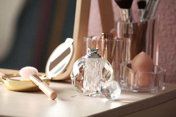 Pocket powder with brush and perfume bottle on dressing table - 写真・画像