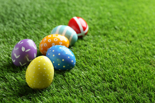 Colorful painted Easter eggs on green grass, space for text - Fotó, kép