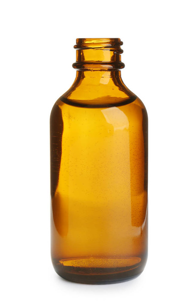 Kleine glazen fles met etherische olie op witte achtergrond - Foto, afbeelding
