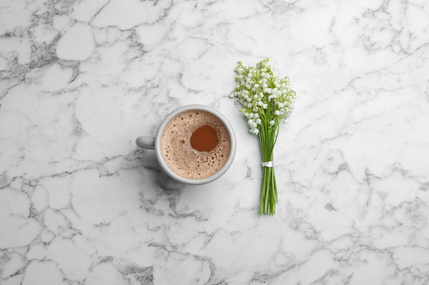 Lily of the valley bouquet and coffee on marble background, flat lay - Foto, Imagem
