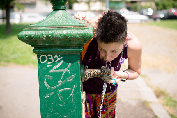 belle femme hipster cheveux courts boire de l'eau dans le parc
 - Photo, image