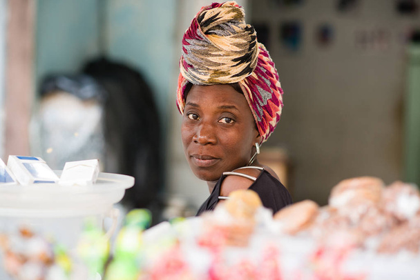 retrato de la vendedora sentada detrás de su puesto de dulces
 - Foto, Imagen