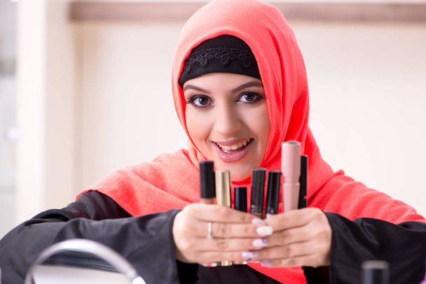 Mooie vrouw in hijab aanbrengen van make-up - Foto, afbeelding