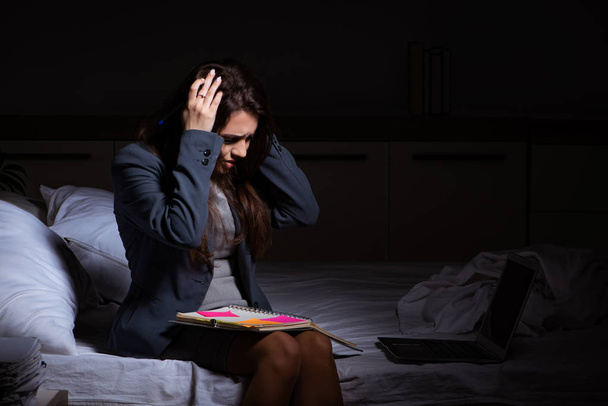 Tired businesswoman working overtime at home at night - 写真・画像