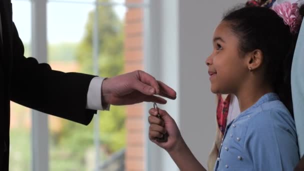 Szczęśliwy dziewczynka biorąc klucze domu z Realtor - Materiał filmowy, wideo