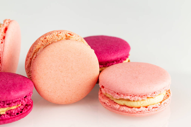 französisch rosa Macarons oder Makronen, Nahaufnahme, Seitenansicht auf weißem Hintergrund. - Foto, Bild