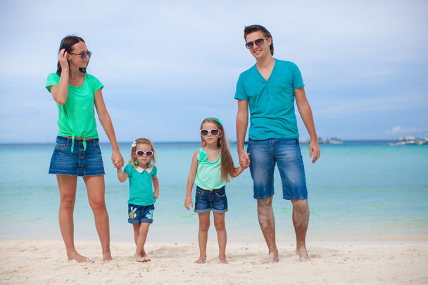 Молодая красивая семья из четырех человек наслаждалась отдыхом на пляже
 - Фото, изображение
