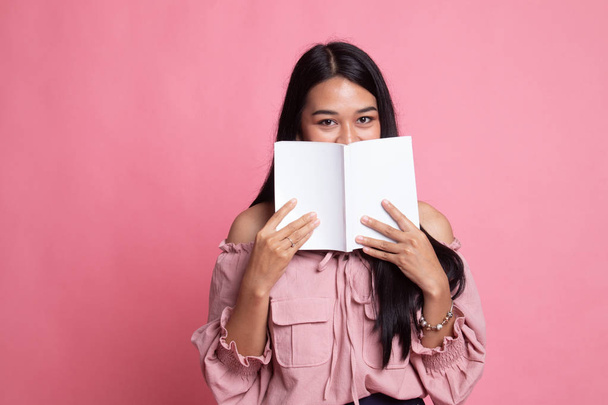 Young Asian woman with a book cover her face. - Foto, Imagen