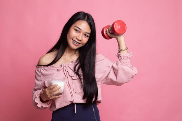 Healthy Asian woman drinking a glass of milk and dumbbell. - Foto, imagen