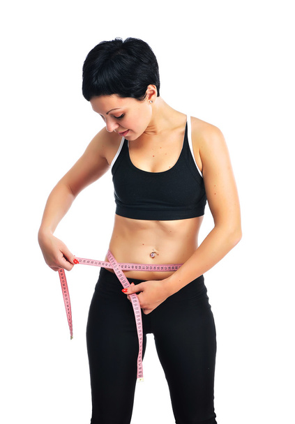 Young fitness woman measuring her waist - Zdjęcie, obraz