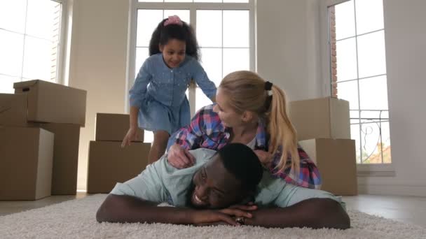 Familia feliz abrazo mientras que hace pila en la alfombra
 - Metraje, vídeo