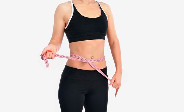 Young fitness woman measuring her waist - Fotografie, Obrázek