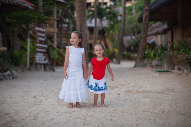 Pequenas garotas adoráveis em resort exótico em vestido agradável
 - Foto, Imagem