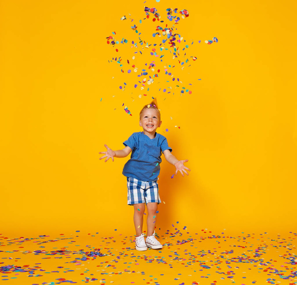 feliz aniversário criança menino com confete no backgroun amarelo
 - Foto, Imagem