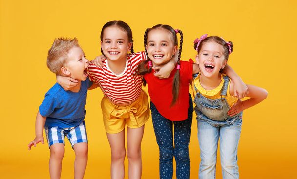 group of cheerful happy children on colored yellow backgroun - Photo, Image