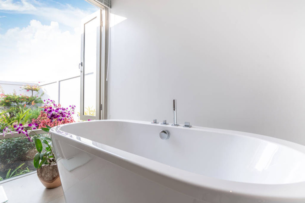 Роскошная ванная комната с ванной и цветком
 - Фото, изображение