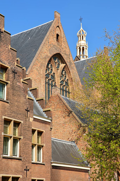 La facciata esterna del Grote di Sint Jacobskerk con la torretta di Oude Stadhuis (vecchio municipio, XVI secolo) sullo sfondo, L'Aia, Paesi Bassi
 - Foto, immagini