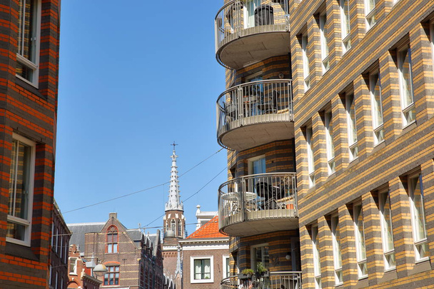 Moderno sviluppo urbano situato su Calliopestraat a L'Aia, Paesi Bassi, con la torre dell'orologio della Chiesa evangelica tedesca sullo sfondo
 - Foto, immagini