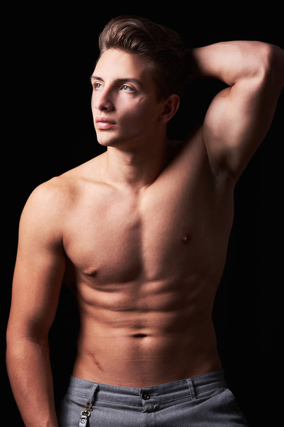 Studio ritratto di bel muscoloso senza maglietta giovane uomo isolato su nero
 - Foto, immagini